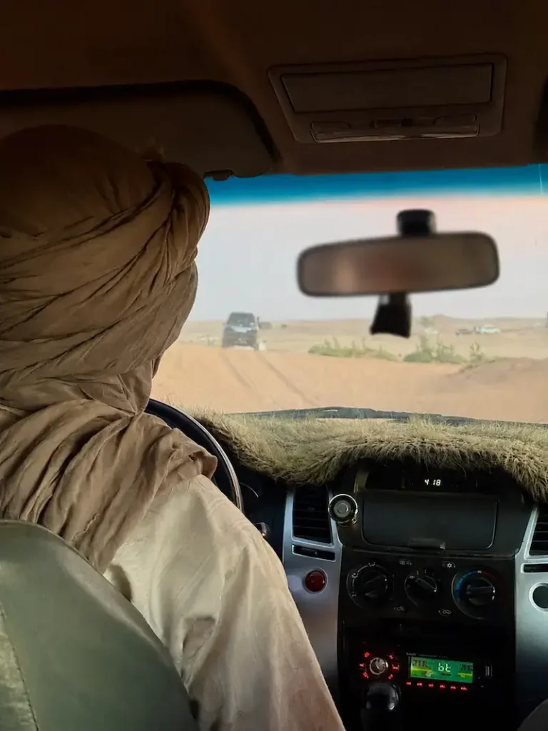 Passenger view from inside a 4x4 vehicle with a local driver, expertly driving through the sandy dunes of the Sahara Desert | Proper Morocco Tours
